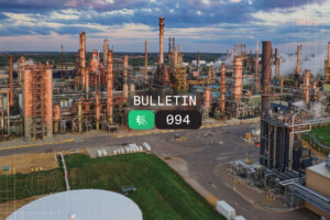 Industrial oil refinery complex with tall distillation columns and piping, overlaid with a dark rounded banner reading 'BULLETIN' and a black badge '094'.